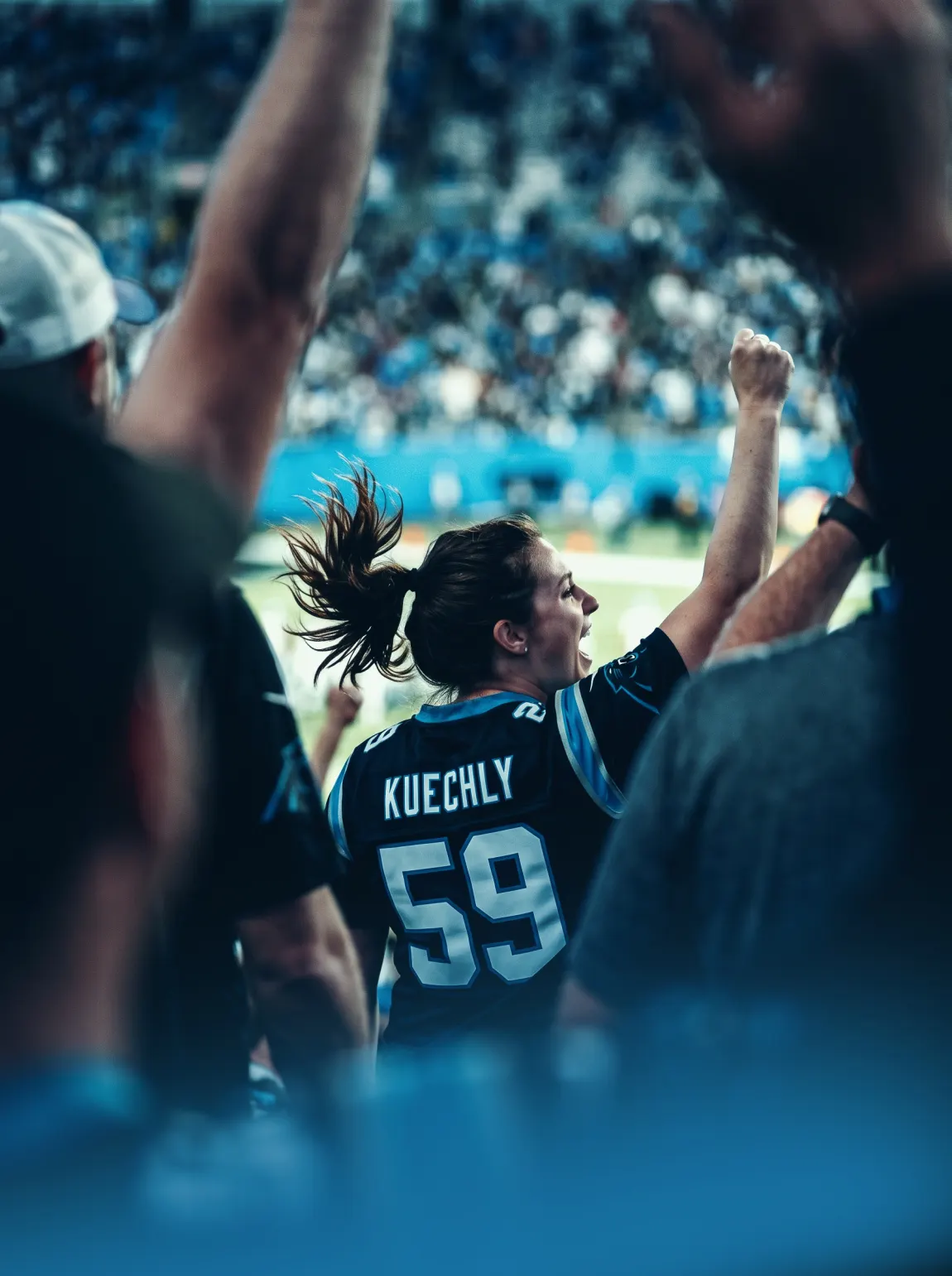 A fan in a Kuechly 59 jersey cheering at a Panthers game